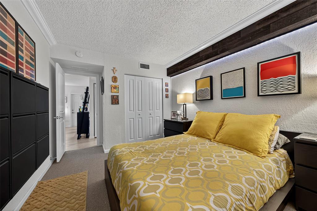 2660 Northeast 8th Avenue, Unit 208 Wilton Manors, FL 33334 - Photo 15 of 49 a bedroom with a bed and a walk in closet