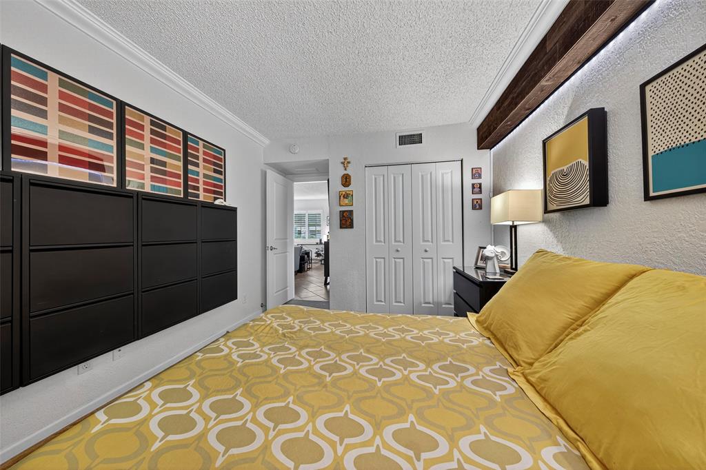 2660 Northeast 8th Avenue, Unit 208 Wilton Manors, FL 33334 - Photo 16 of 49 a bedroom with a bed and a cabinets