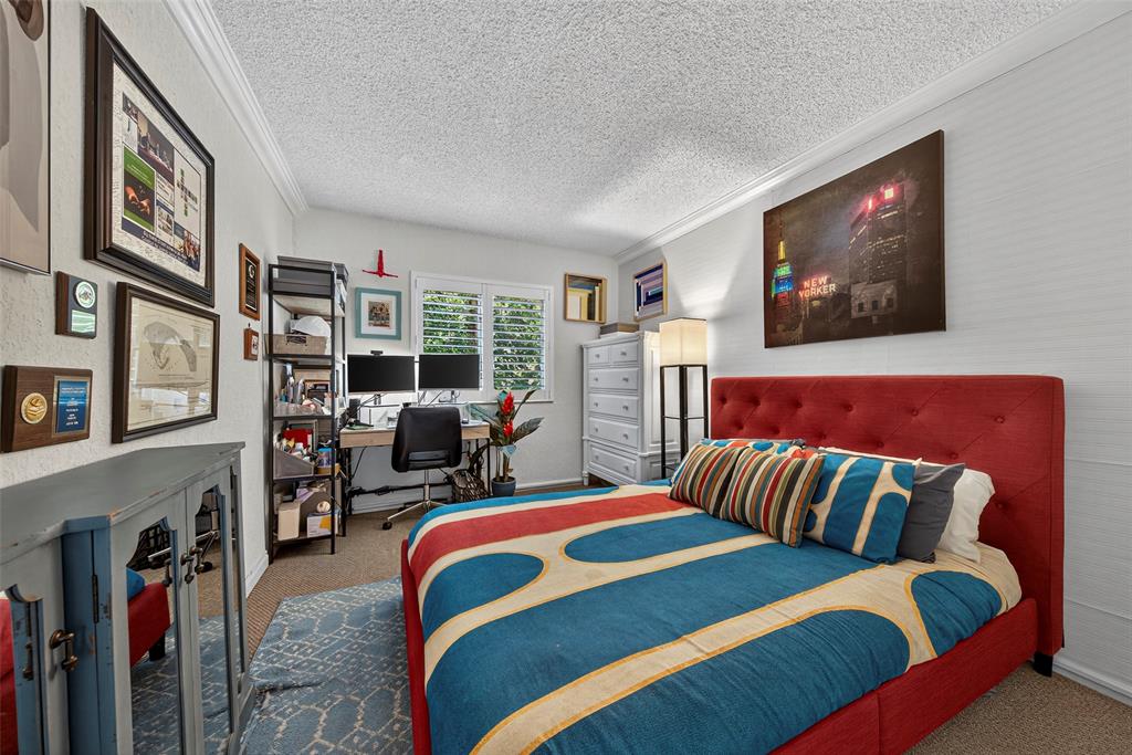 2660 Northeast 8th Avenue, Unit 208 Wilton Manors, FL 33334 - Photo 17 of 49 a bedroom with furniture and a flat screen tv