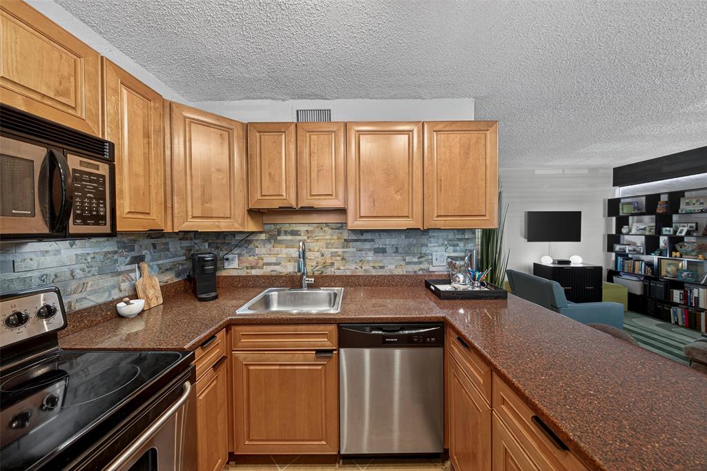 2660 Northeast 8th Avenue, Unit 208 Wilton Manors, FL 33334 - Photo 2 of 49 a kitchen with stainless steel appliances granite countertop a sink stove and cabinets