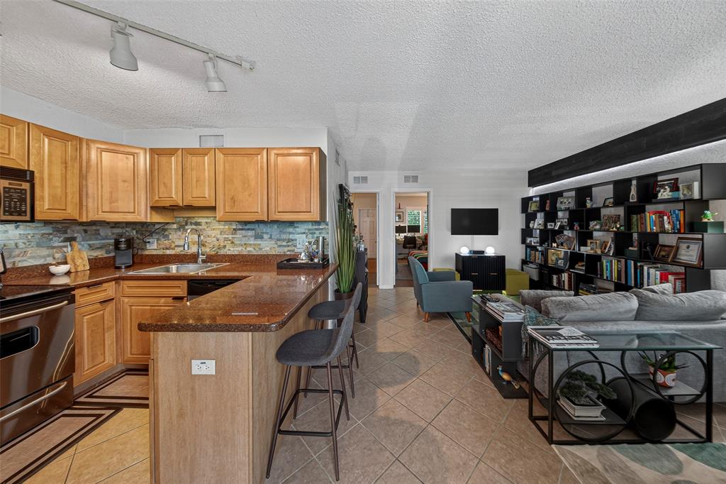 2660 Northeast 8th Avenue, Unit 208 Wilton Manors, FL 33334 - Photo 4 of 49 a kitchen with stainless steel appliances granite countertop a stove a sink and a refrigerator