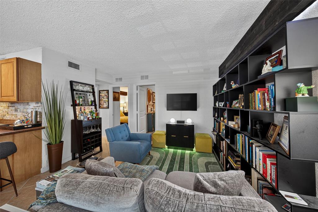 2660 Northeast 8th Avenue, Unit 208 Wilton Manors, FL 33334 - Photo 6 of 49 a living room with furniture and a flat screen tv
