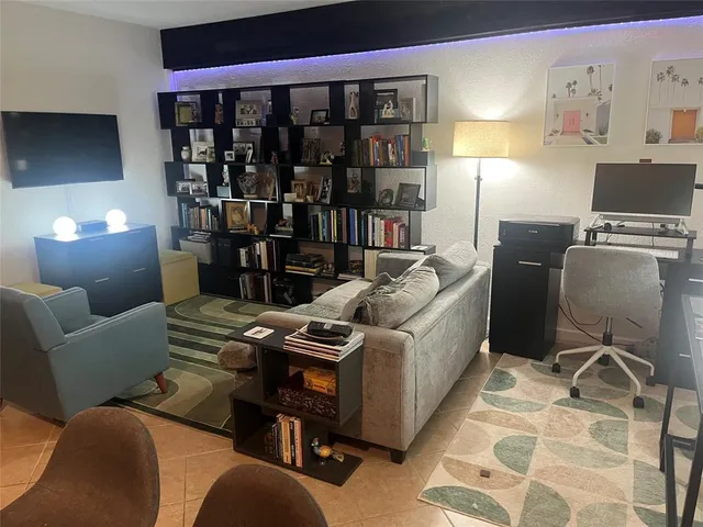a living room with furniture a lamp and a flat screen tv