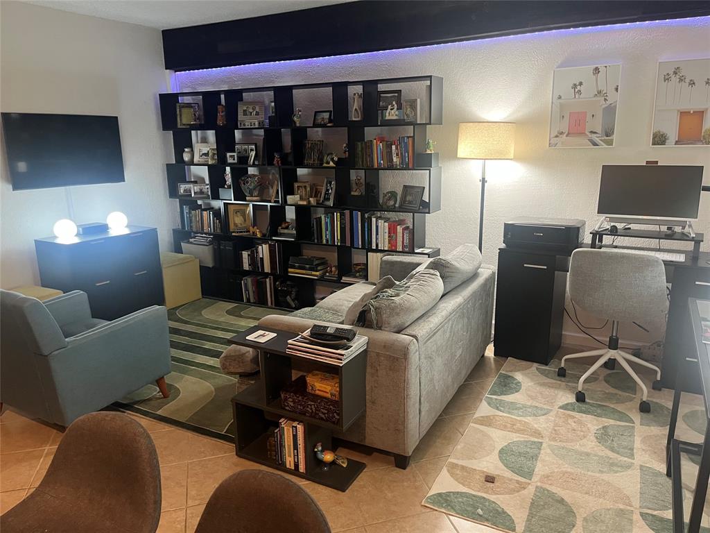 2660 Northeast 8th Avenue, Unit 208 Wilton Manors, FL 33334 - Photo 10 of 49 a living room with furniture a lamp and a flat screen tv