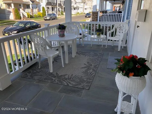 a view of a patio with table and chairs potted plants and wooden floor
