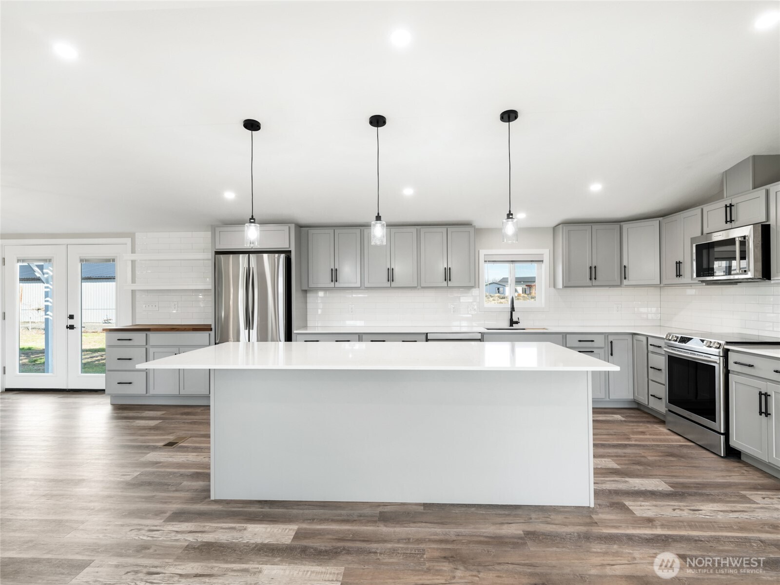 734 Lakeside Way Mattawa, WA 99349 - Photo 5 of 34 a large kitchen with kitchen island a stove a sink a center island and wooden floor