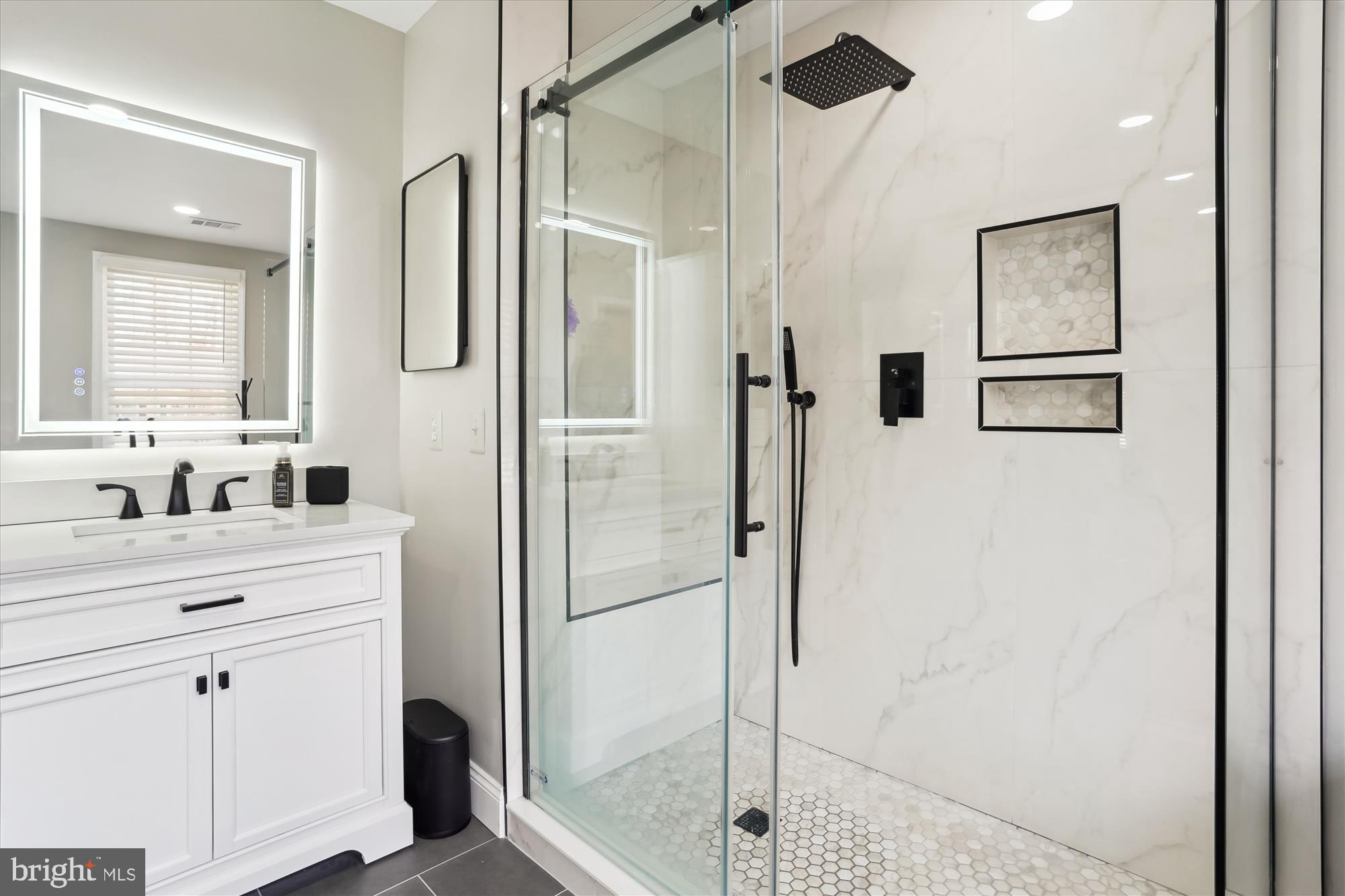 8535 Oak Chase Circle Fairfax Station, VA 22039 - Photo 35 of 62 a bathroom with a shower sink and mirror