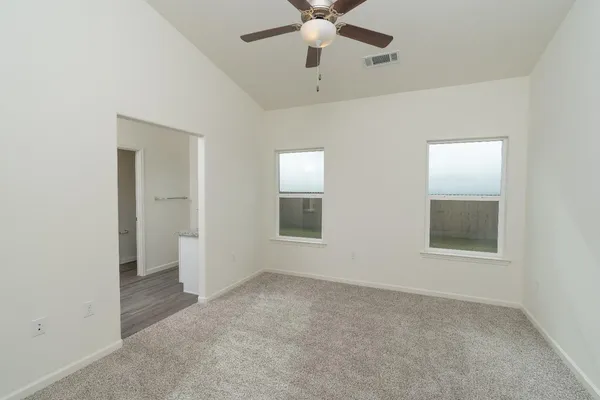 an empty room with a ceiling fan and a window