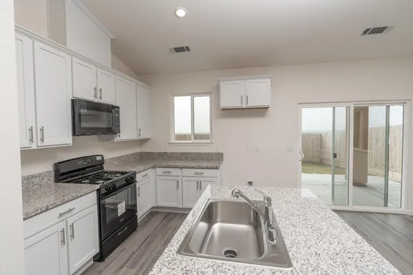 a kitchen that has a sink and a stove top oven