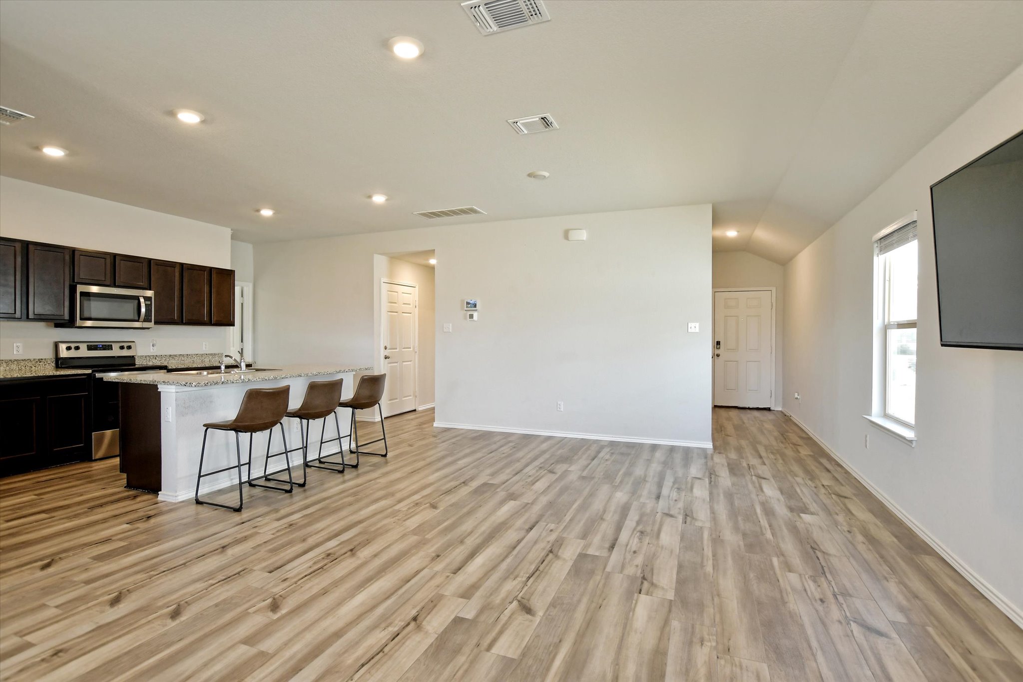 508 Wyatt Way Jarrell, TX 76537 - Photo 26 of 27 Kitchen with a breakfast bar area, stainless steel appliances, open floor plan, and light stone countertops