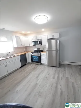 a kitchen with stainless steel appliances granite countertop a refrigerator sink and stove