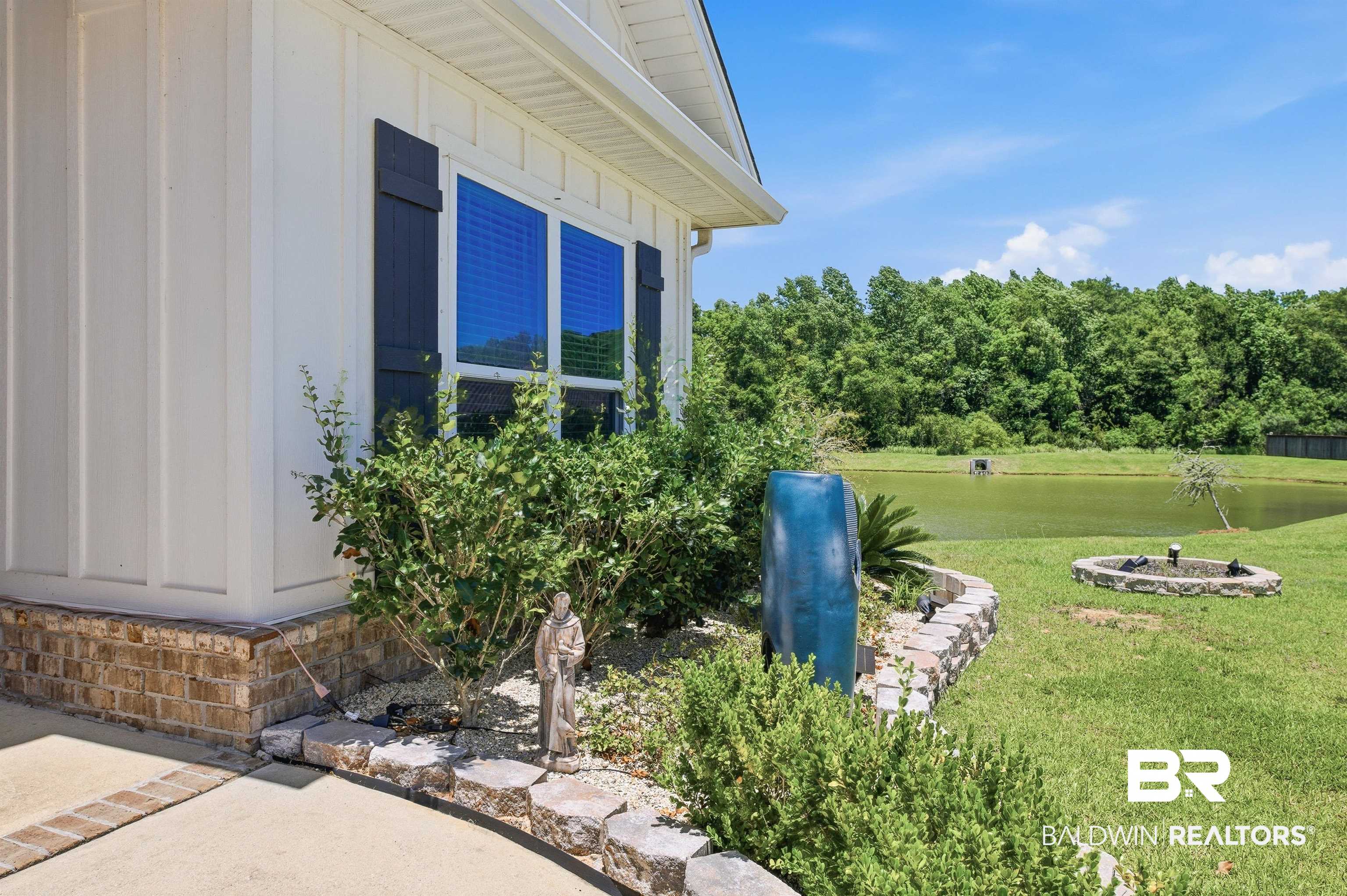 8735 Bronze Lane Foley, AL 36535 - Photo 50 of 58 Exterior featuring white board and batten siding, dark louvered shutters, and a brick foundation