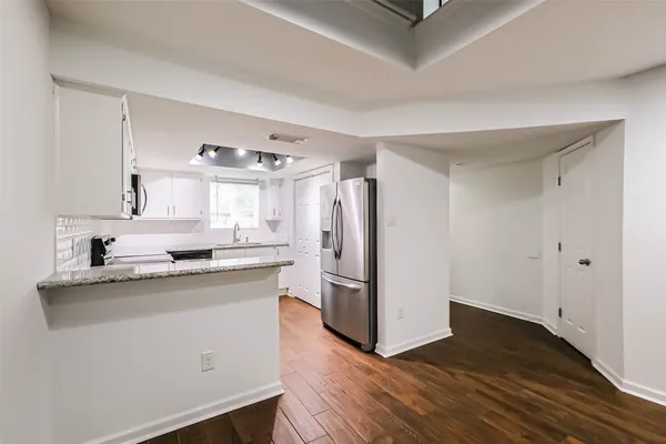 a kitchen with a refrigerator sink and cabinets