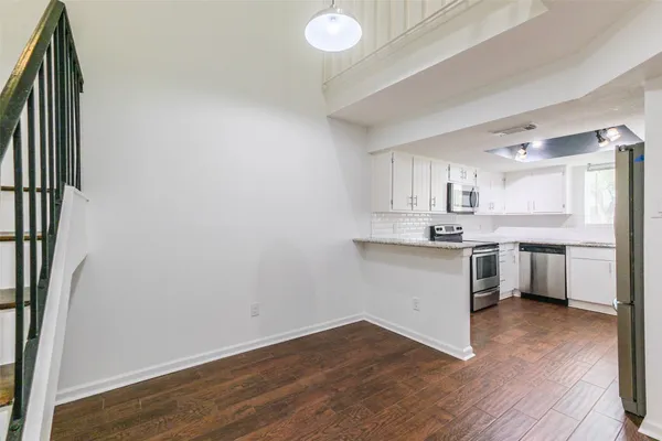 a kitchen with a white refrigerator freezer a sink and dishwasher a oven with wooden floors