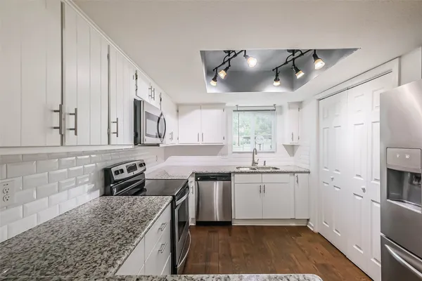 a kitchen with stainless steel appliances granite countertop a sink stove and refrigerator