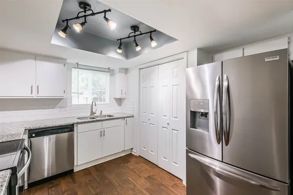 a kitchen with a refrigerator a sink and cabinets