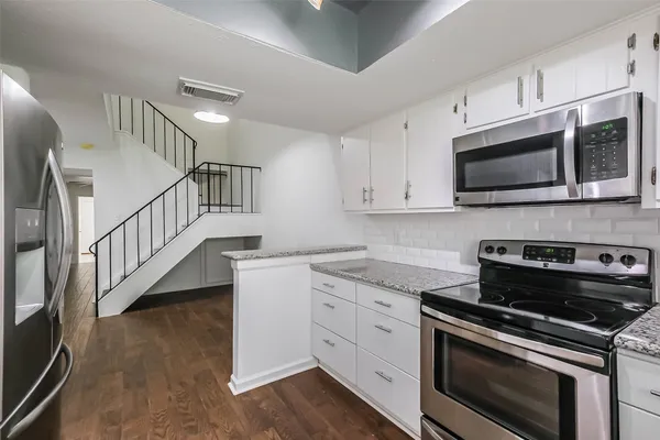 a kitchen with stainless steel appliances kitchen island granite countertop a stove a sink and a microwave