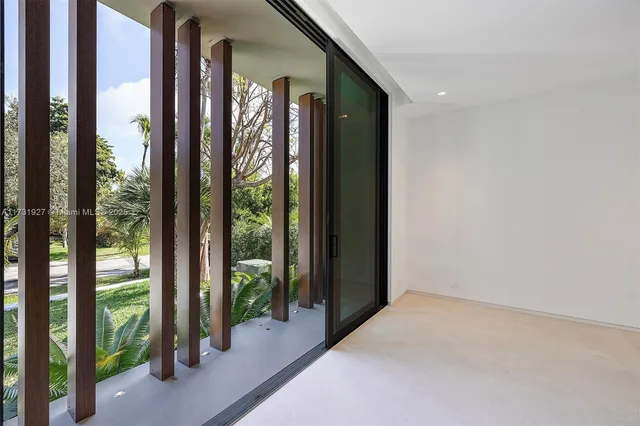 a spacious bedroom with a large window and balcony
