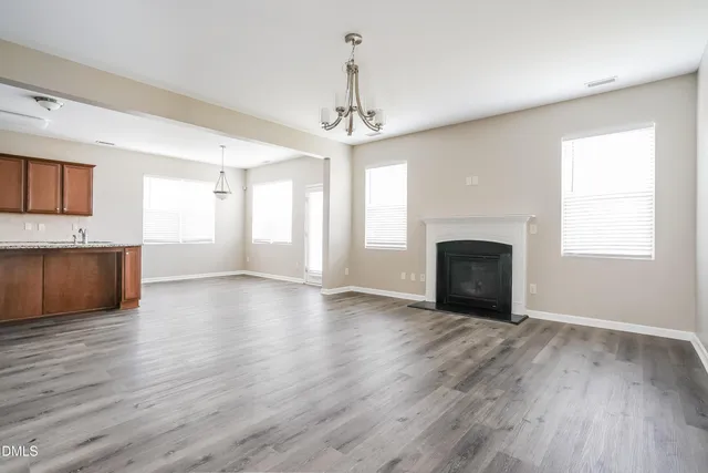 a view of an empty room with a fireplace and a window