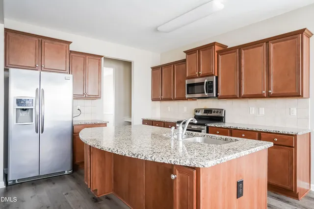a kitchen with stainless steel appliances granite countertop a sink stove and refrigerator