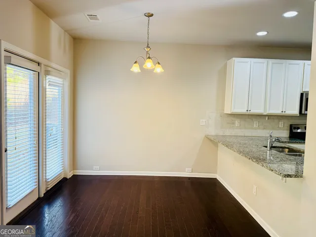 a kitchen that has a lot of cabinets and wooden floor