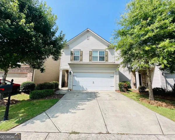 a view of a white house with a yard and plants