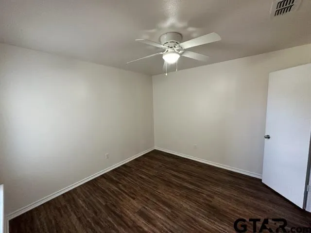 a view of an empty room with wooden floor