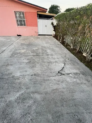 a view of a dry yard with wooden fence