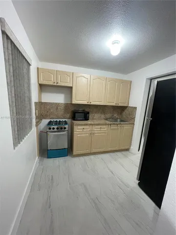 a view of a kitchen with microwave and cabinets