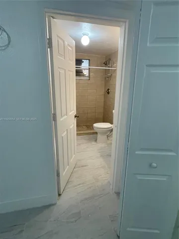 a bathroom with a granite countertop shower and a toilet