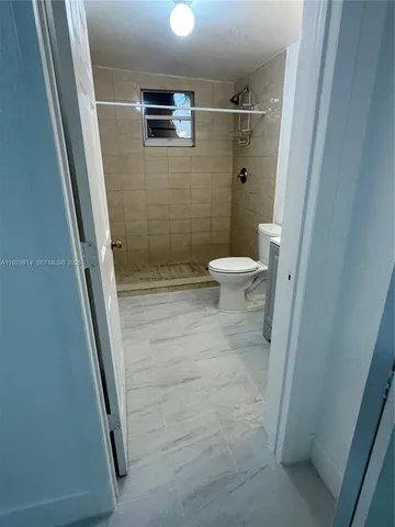 a bathroom with a granite countertop shower and a toilet