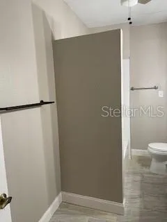 a view of bathroom with a shower and a toilet