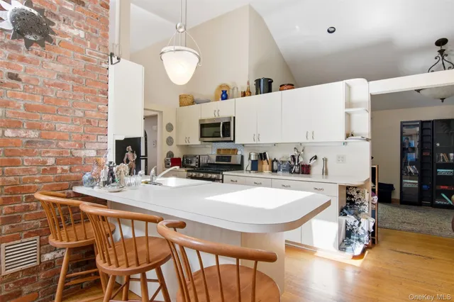 a kitchen with stainless steel appliances granite countertop a stove a sink a microwave and a refrigerator