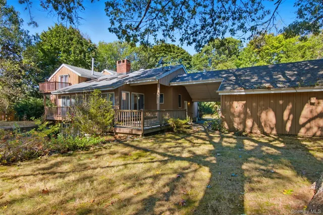 a view of a house with a large tree and a yard