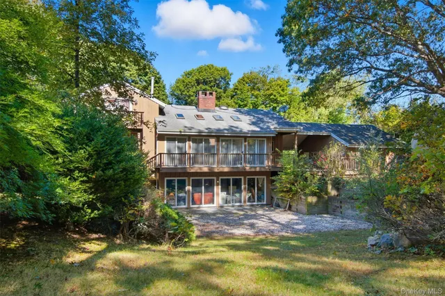 a view of house with yard and sitting area