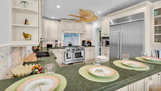 a kitchen with stainless steel appliances granite countertop a sink and white cabinets