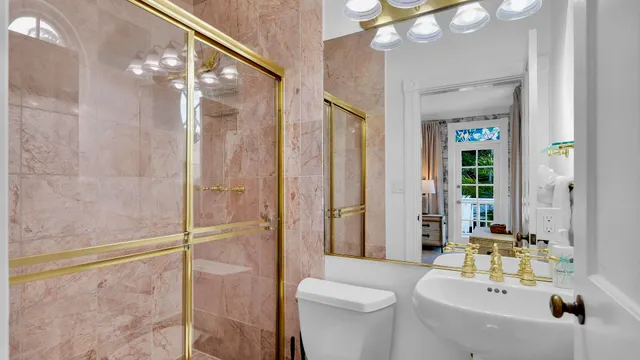 a bathroom with a sink a toilet and shower