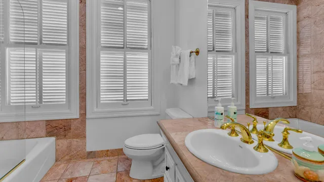 a bathroom with a granite countertop sink and a mirror with bathtub