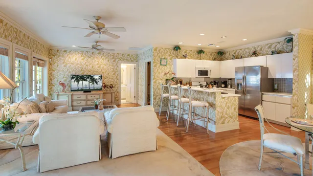 a living room with lots of furniture and kitchen view