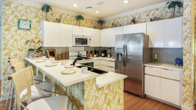 a kitchen with stainless steel appliances a sink a stove a refrigerator and cabinets