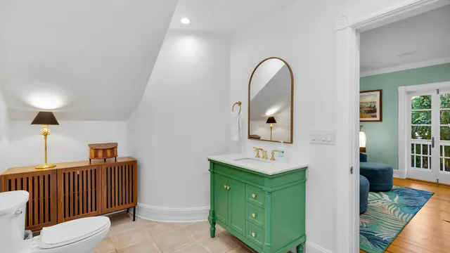 a bathroom with a toilet sink and mirror