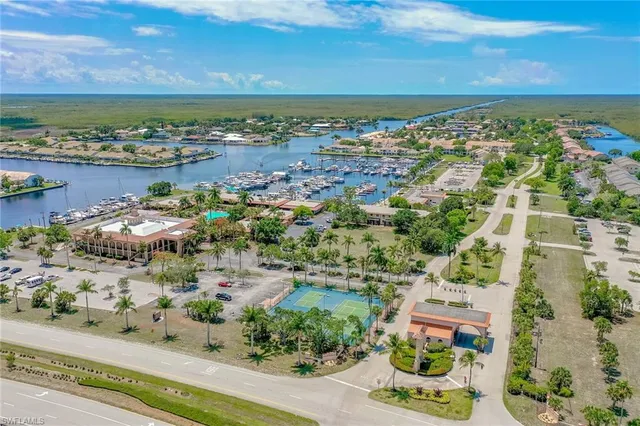 an aerial view of ocean and residential houses with outdoor space
