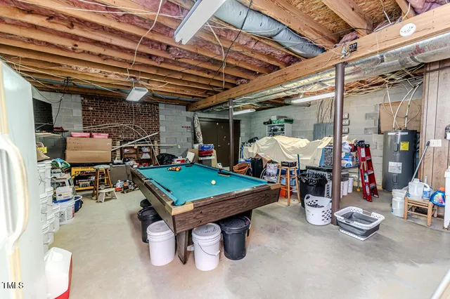 a large living room with stainless steel appliances kitchen island granite countertop a refrigerator and a sink