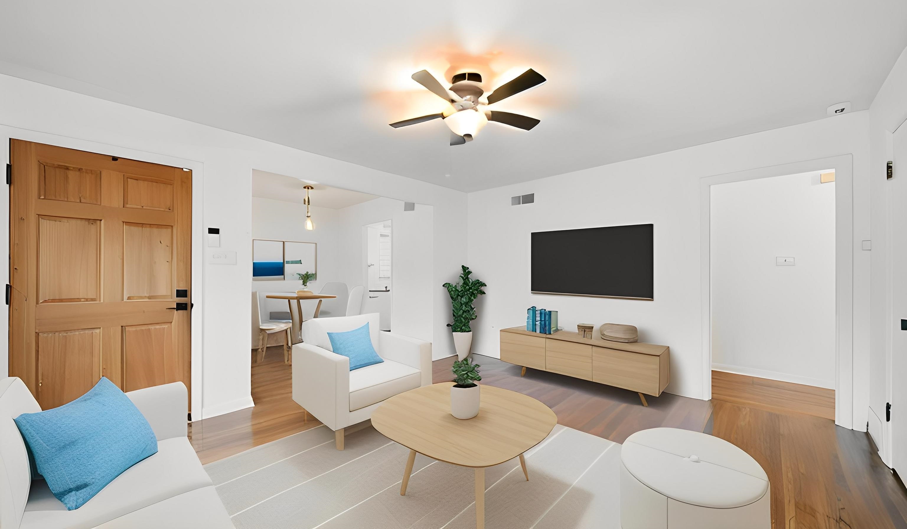 Staged living area featuring wood finished floors and ceiling fan