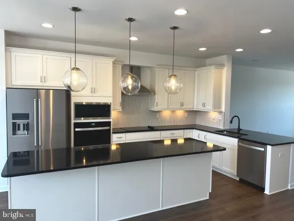 a kitchen with stainless steel appliances granite countertop a sink a refrigerator a stove and a wooden floors