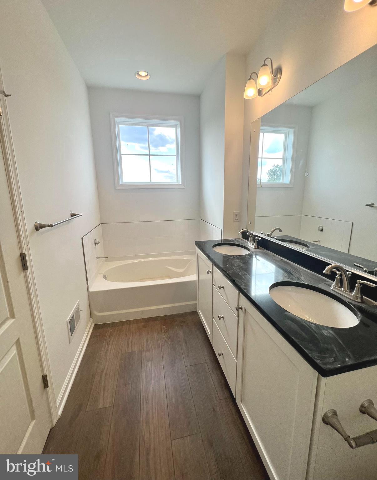 3141 Eton Place Winchester, VA 22601 - Photo 23 of 41 a bathroom with a granite countertop sink a mirror a bathtub and a window