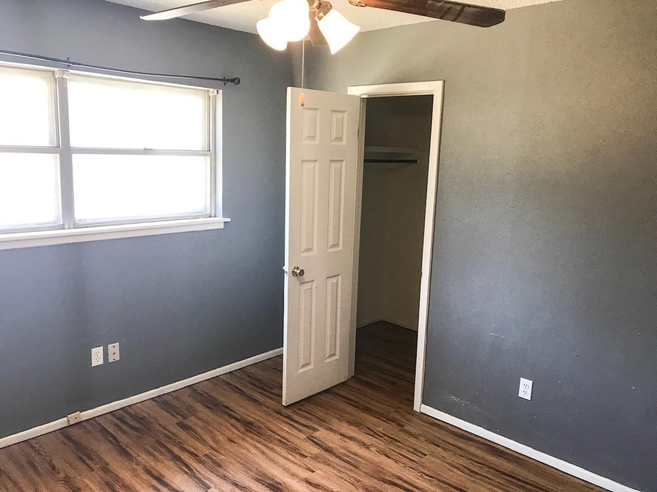3520 Bangor Drive Lubbock, TX 79407 - Photo 10 of 11 an empty room with wooden floor and windows