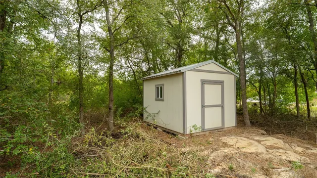 a view of a small house with a tree in the background
