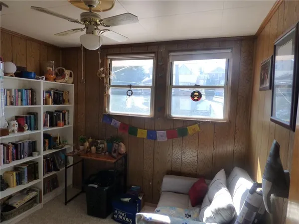 a living room with furniture a bookshelf and a window