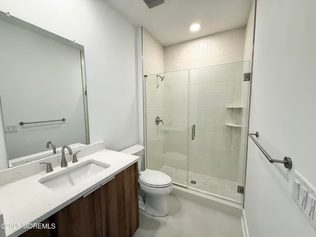 a bathroom with a double vanity sink toilet and shower